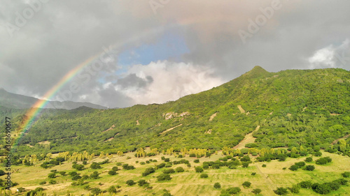 Beautiful island hills with rainbow at sunset