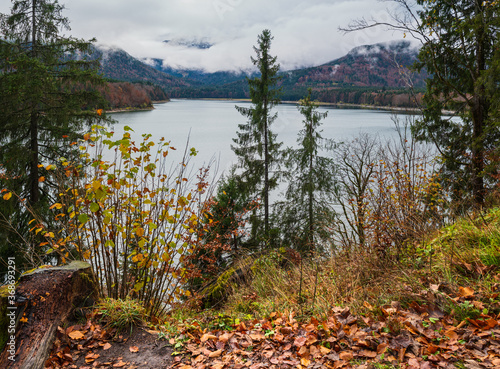 Alpine  Sylvenstein Stausee lake on Isar river, Bavaria, Germany. Autumn overcast, foggy and drizzle day. Picturesque traveling, seasonal, weather, and nature beauty concept scene. photo