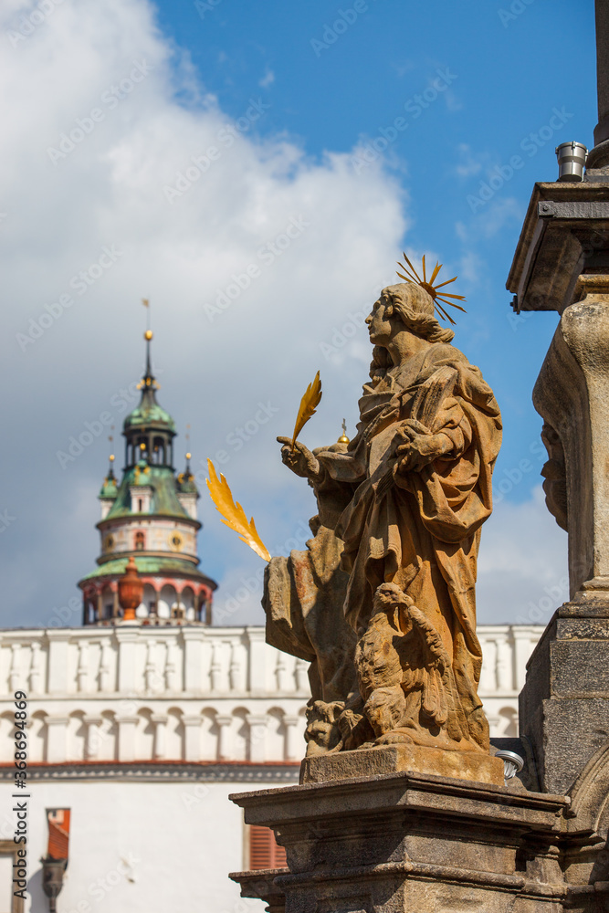 Obraz premium Chesky Krumlof statues with bell tower in distance