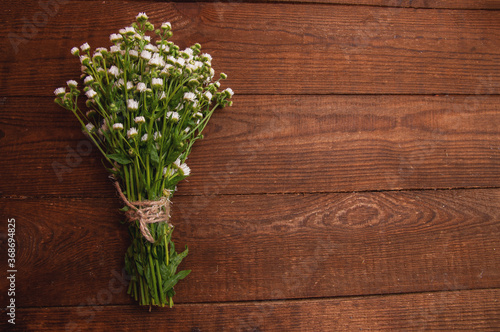 bouquet of chamomile flowers  which lies on a wooden table