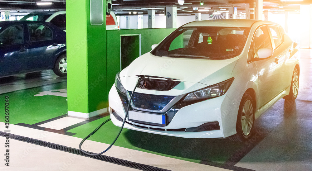 Eco auto. Electric car charge battery on eco energy charger station