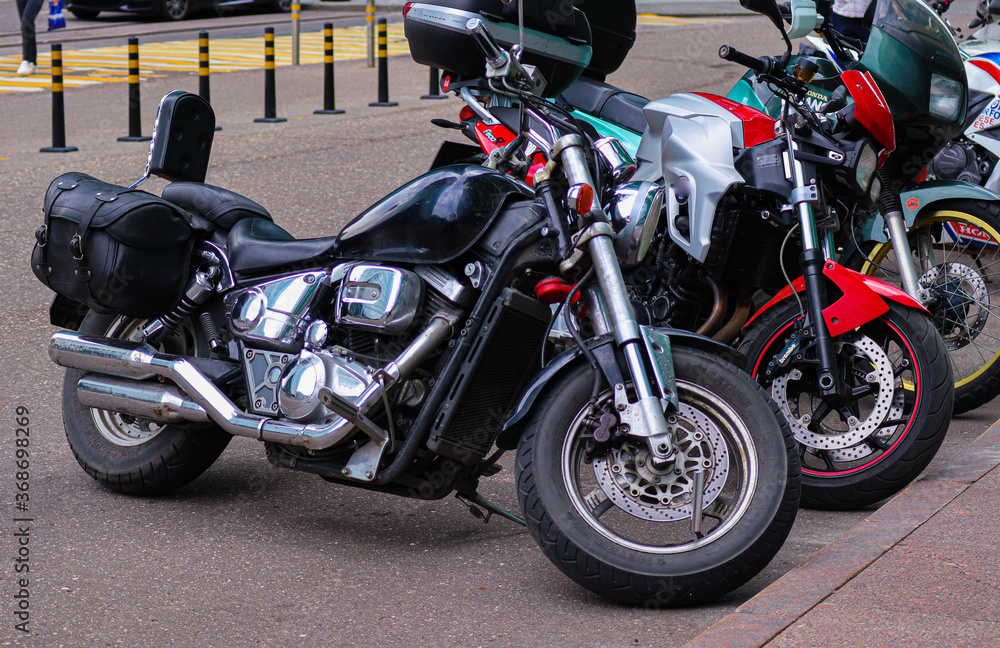 Transport motorcycles stand in a row near a high-rise building. Racing motorbikes.