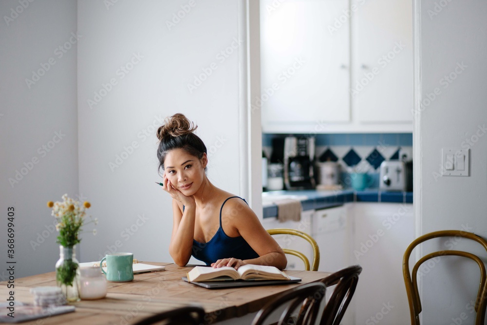 Young Asian woman working from home on kitchen dining table Young Asian woman working from home on kitchen dining table