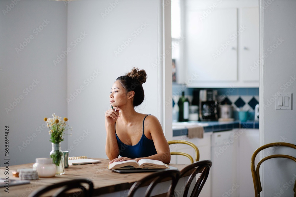 Young Asian woman working from home on kitchen dining table