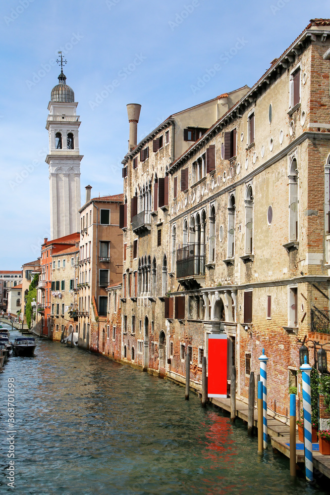 Narrow canal lined with houses in Venice, Italy