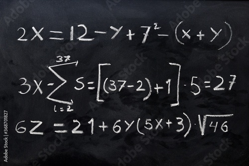 Ecuaciones matemáticas escritas a mano con una tiza blanca en la pizarra	