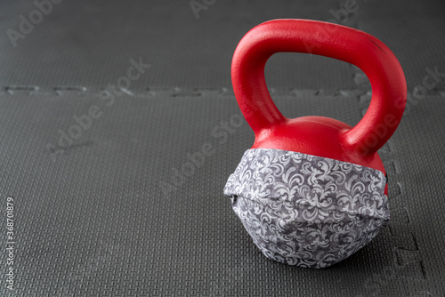 Fitness during a pandemic, fabric face mask and a red kettlebell 