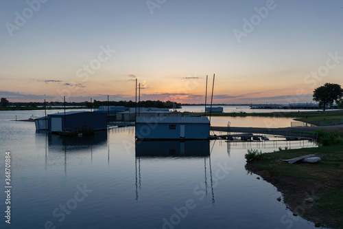 Boathouses in a marina on a calm lake at sunrise