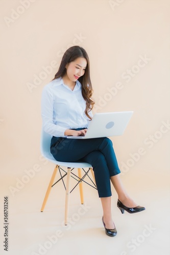 Portrait beautiful young business asian woman sit on chair with laptop or smart phone