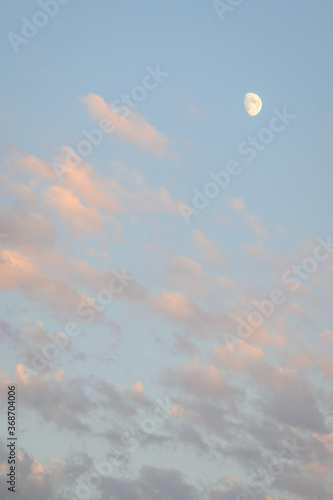 Peaceful sky at dusk  light clouds and partial moon  as a nature background 