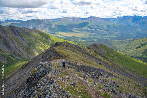 Person hiking through spectacular Tombstone Territorial Park located in Northern Canada, Yukon Territory during the summertime. 