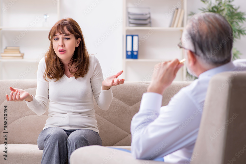 Young woman visiting old male doctor psychologist Young woman visiting old male doctor psychologist