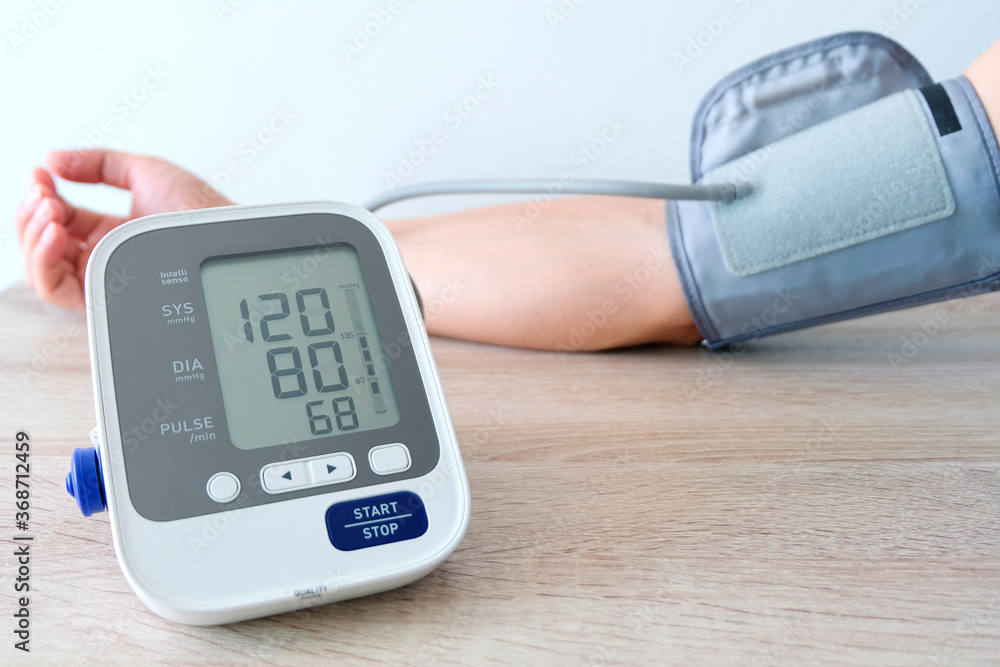 Man check blood pressure monitor and heart rate monitor with digital pressure gauge. Health care and Medical concept Man check blood pressure monitor and heart rate monitor with digital pressure gauge. Health care and Medical concept