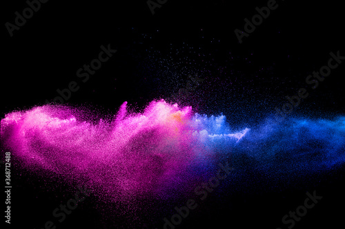 Pink blue dust particles splash on black background.Pink blue powder splash.