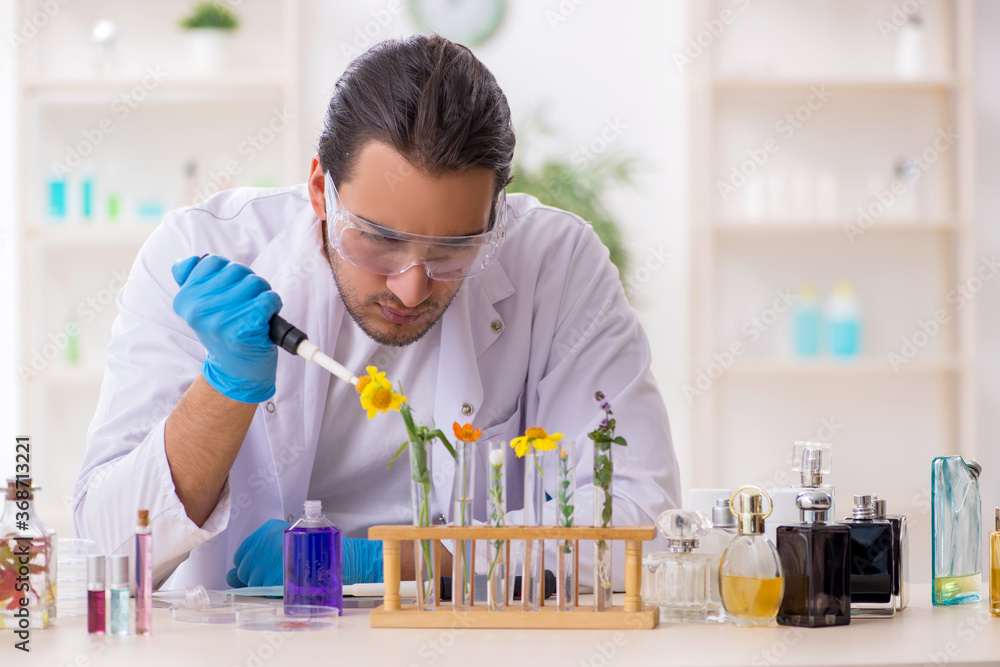 Young male chemist in perfume synthesis concept Young male chemist in perfume synthesis concept