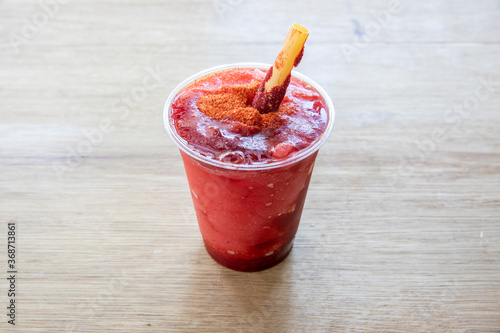 Chamoyada is a mexican fresh beverage made with chamoy, ice and fruit. photo