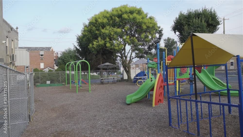 A Playground with swings and play areas in the courtyard of the kindergarten, fenced for the safety of children with an iron fence. A Playground with swings and play areas in the courtyard of the kindergarten, fenced for the safety of children with an iron fence.