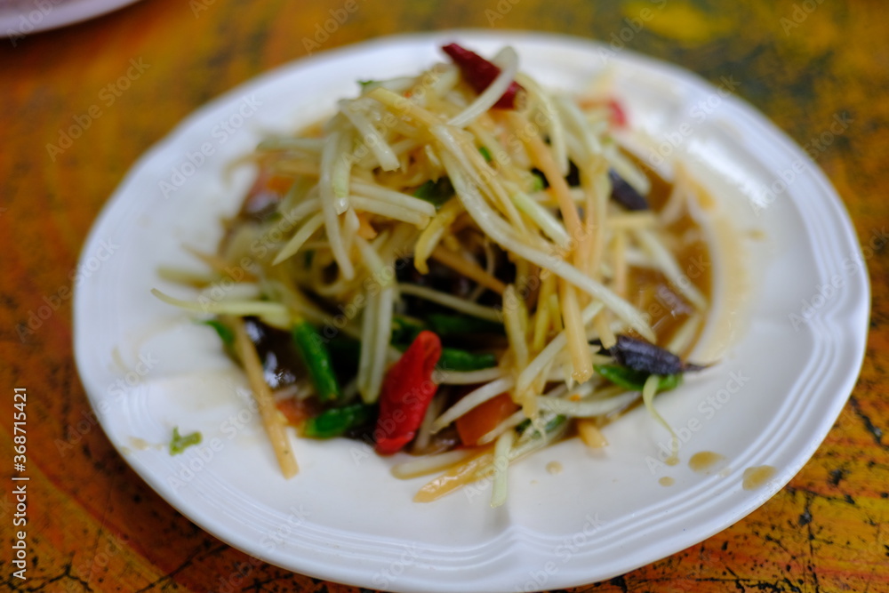Spicy papaya salad or Somtum in Thai language serving on the table ,Thai food Spicy papaya salad or Somtum in Thai language serving on the table ,Thai food
