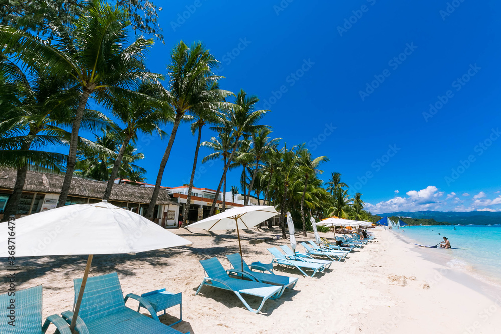 フィリピン・ボラカイ島のホワイトビーチに並ぶパラソルと青空