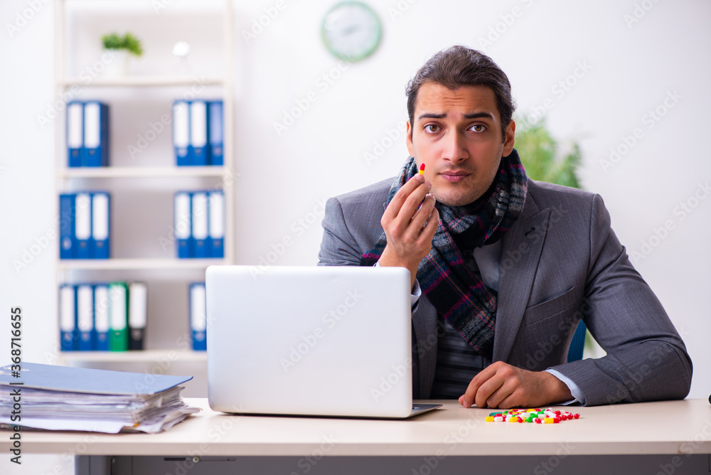 Young male employee suffering at workplace Young male employee suffering at workplace