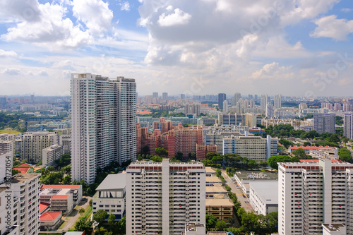 Panoramic landscape of public residential buildings (HDB flats) in Toa Payoh central in Singapore, on bright sunny day. Greenery is interspersed among the dense high rise architecture. Aerial view