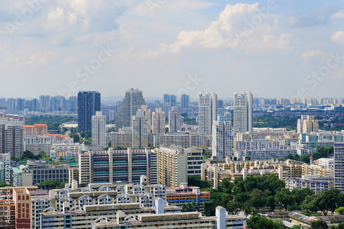 Singapore skyline of typical heartland neighbourhood  on a sunny day. Panoramic architectural shot. Greenery is interspersed among the dense high rise  colourful public housing buildings  HDB flats 