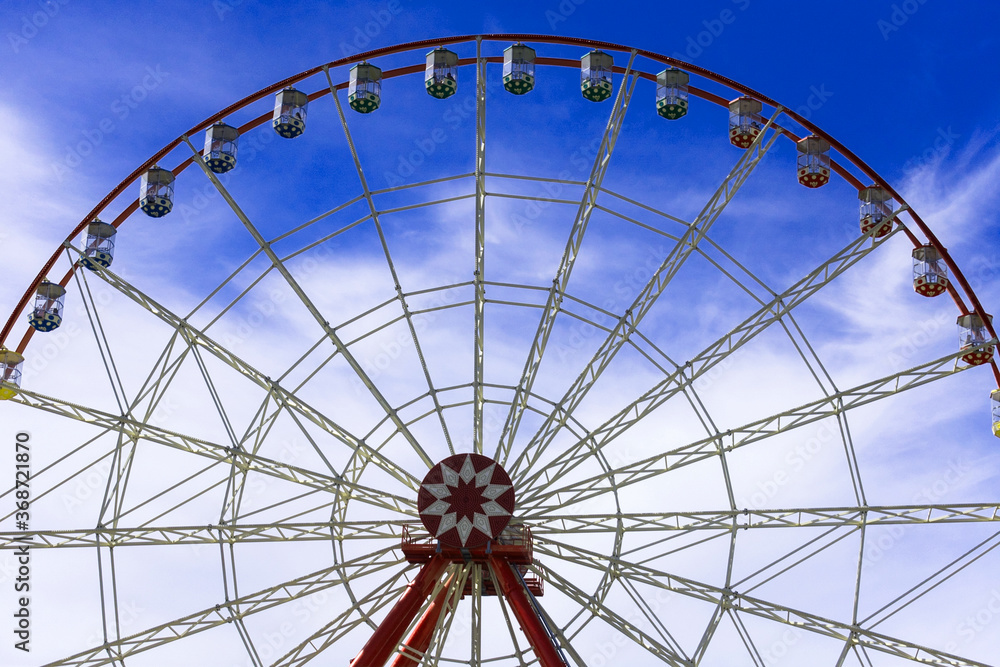 Big Ferris wheel against the blue sky.