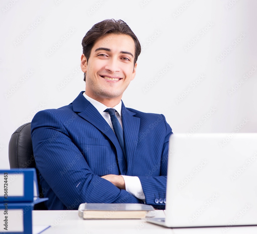 Young handsome businessman employee working in office at desk Young handsome businessman employee working in office at desk