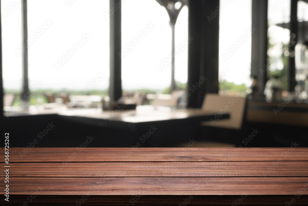 Empty wooden desk space and blurry background of coffee shop or Restaurant for product display montage. Empty wooden desk space and blurry background of coffee shop or Restaurant for product display montage.