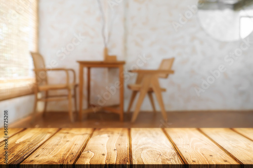 Empty wooden desk space and blurry background of coffee shop or Restaurant for product display montage.