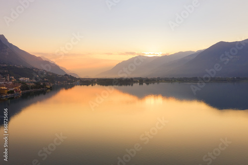 Drone view of Lake Iseo at sunrise  on the left the city of lovere which runs along the lake Bergamo Italy.