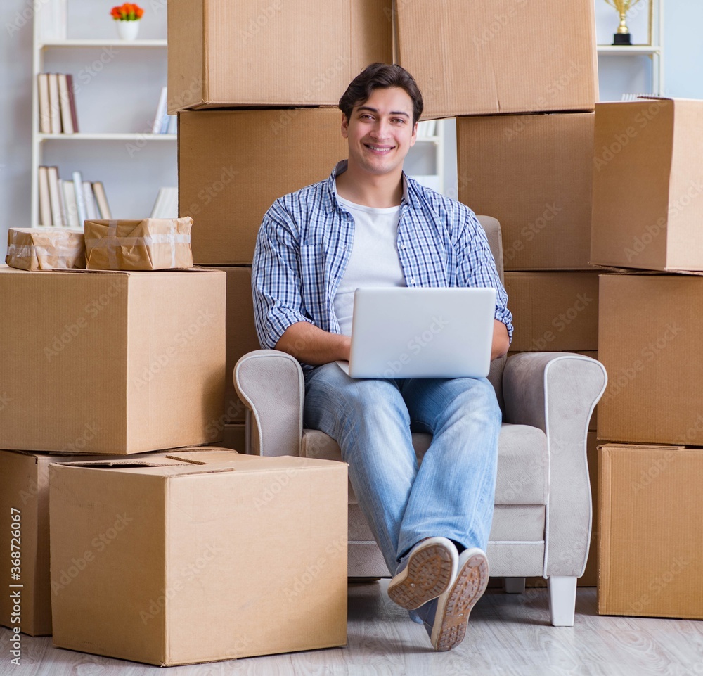 Young man moving in to new house with boxes Young man moving in to new house with boxes