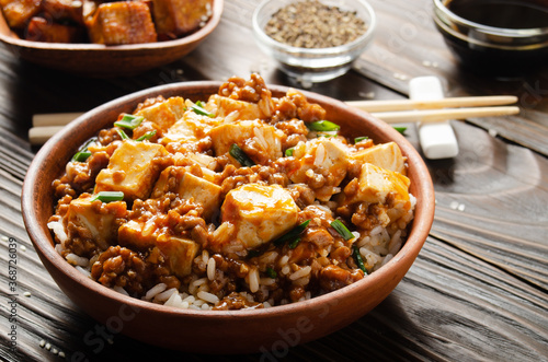 Authentic traditional Chinese food mapo tofu dish with pork chives steamed rice soy sauce and spices closeup