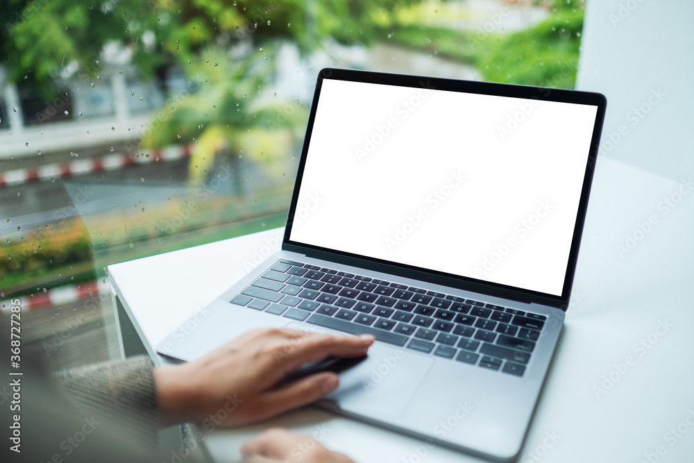 Mockup image of a hand using and touching on laptop computer touchpad with blank white desktop screen Mockup image of a hand using and touching on laptop computer touchpad with blank white desktop screen