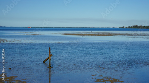 View across the blue water of Moreton Bay at low tide, with Redland Bay and islands in the distance. Victoria Point, Queensland, Australia. © Silky Oaks