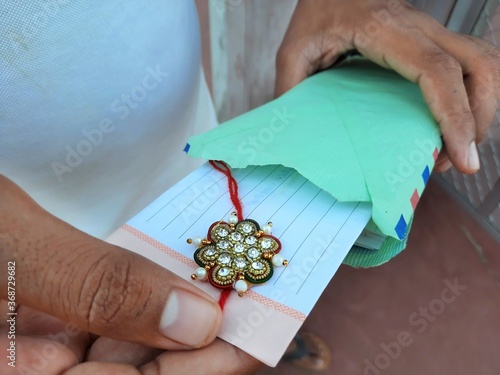 male opening rakhee envelope with message on Raksha Bandhan photo