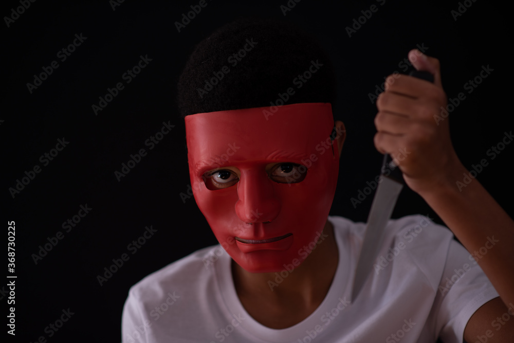 Ominous looking person wearing a mask with knife in hand Ominous looking person wearing a mask with knife in hand