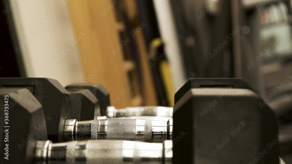 Muscular hand putting down a dumbbell weight on a weight rack in a gym. Body building
Muscular hand putting down a dumbbell weight on a weight rack in a gym. Body building