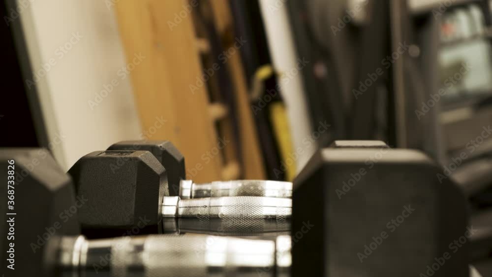 Dumbbells rack Veiny male hand taking dumbbell from weight rack. strength training equipment in gym. Muscle built body builder athlete Dumbbells rack Veiny male hand taking dumbbell from weight rack. strength training equipment in gym. Muscle built body builder athlete