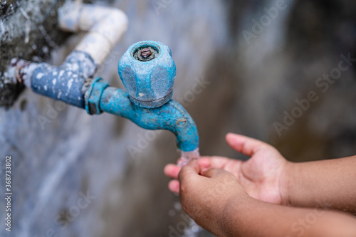 Little kid washing hand under the faucet with water. clean and Hygiene concept.
