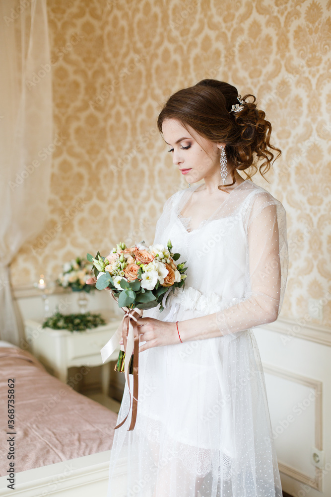 Pretty young Bride.Brown-haired woman with classic wedding hair-style. Boudoir morning of the bride. Pretty young Bride.Brown-haired woman with classic wedding hair-style. Boudoir morning of the bride.