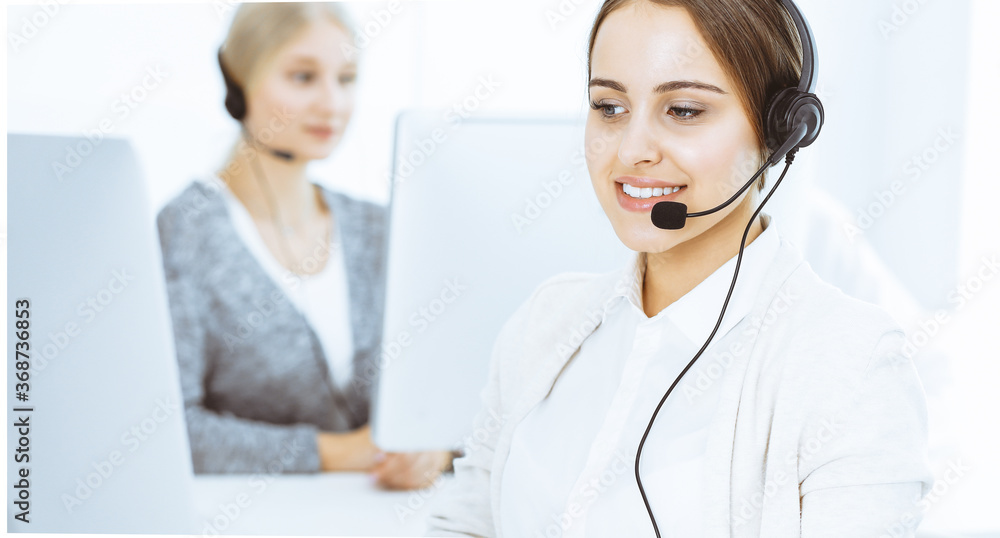 Call center. Group of diverse operators at work. Beautiful woman in headset communicating with customers of telemarketing service. Business concept Call center. Group of diverse operators at work. Beautiful woman in headset communicating with customers of telemarketing service. Business concept