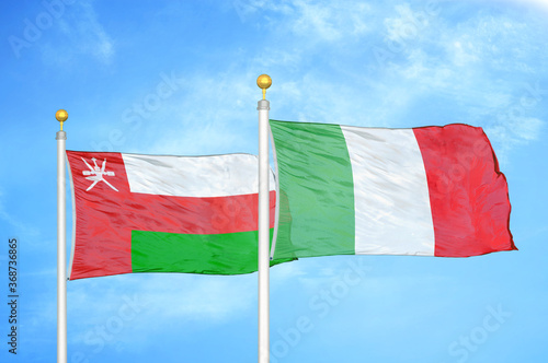 Oman and Italy two flags on flagpoles and blue sky