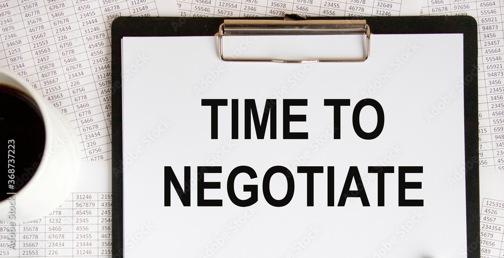 Text Time to negotiate on the page of a notepad lying on financial charts on the office desk. Near the calculator. Business concept. Text Time to negotiate on the page of a notepad lying on financial charts on the office desk. Near the calculator. Business concept.