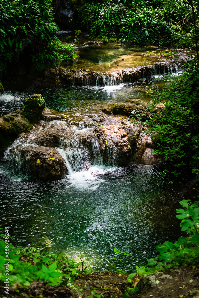 Small waterfall in the forest in hot summer day Small waterfall in the forest in hot summer day