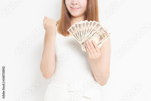 お金を手に持つ若い女性