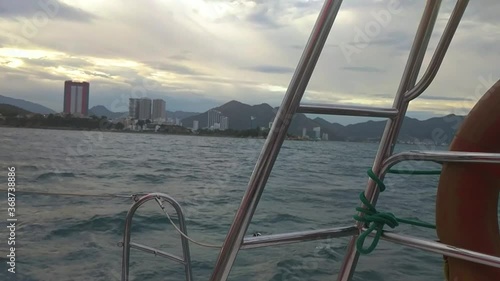 Wallpaper Mural View of buildings and mountains from a moving ferry in the ocean. Boat sailing in the wavy ocean at morning, view of the city from afar. Torontodigital.ca