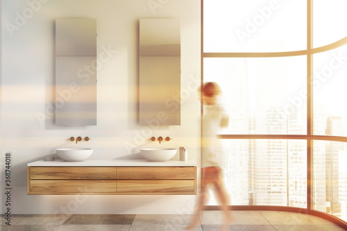 Woman walking in white bathroom