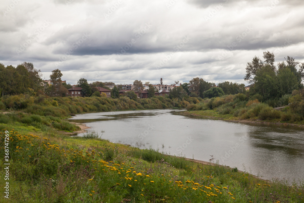 Summer landscape with river and clouds. Small russian town