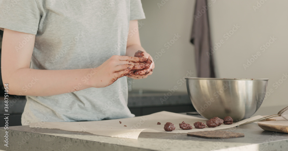 young woman making chocolate truffles on home kictchen young woman making chocolate truffles on home kictchen